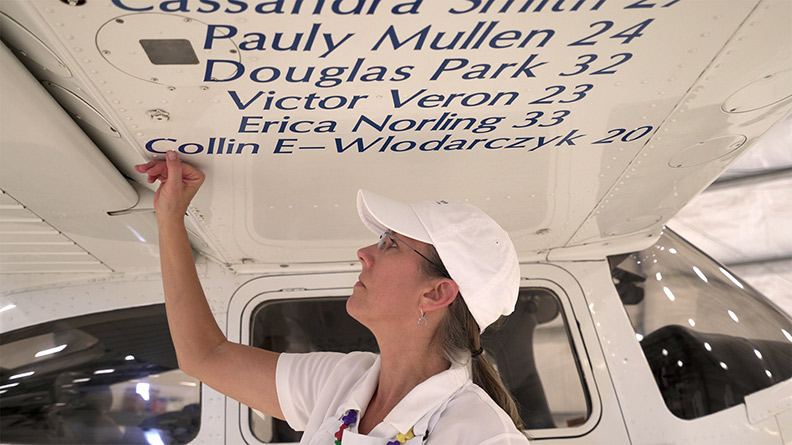 SafeLaunch co-founder Janet Rowse applies the name of a young adult to the SafeLaunch airplane